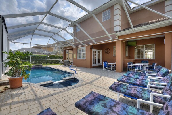 A covered outdoor area with a swimming pool, lounge chairs, and a patio table. - 6 Bed, 2 Suites, Pool, Spa, Games Room #800 6 Bedroom Villa (Davenport)