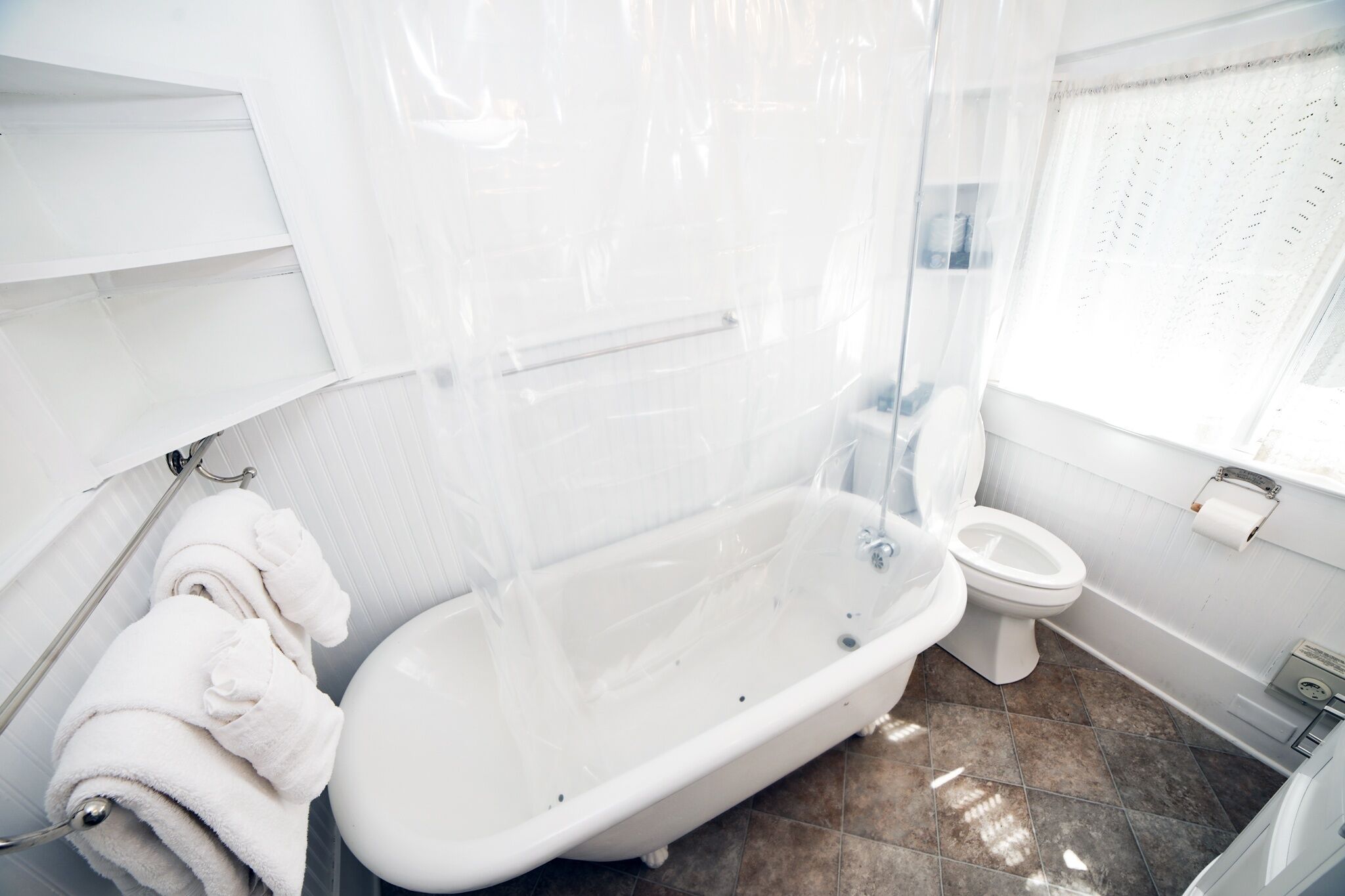 A modern bathroom with a freestanding bathtub, a toilet, and a shower enclosure.