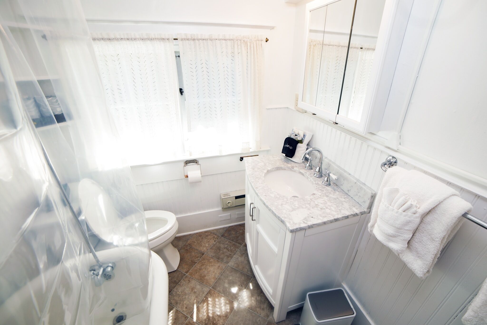 A bathroom with a toilet, sink, and shower.
