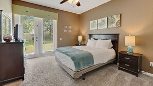 A bedroom with a bed, nightstands, a ceiling fan, and artwork on the wall. - Vista Cay Resort, Next To Universal 821 3 Bedroom Townhouse (Orlando)
