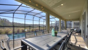 Un patio exterior cubierto con piscina, mesa de comedor, sillas y una zona de estar.