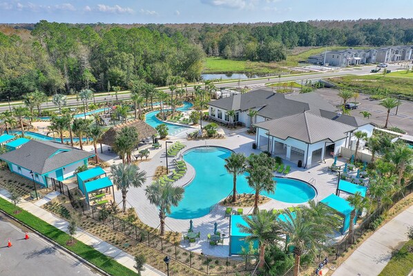 Un resort con varias piscinas, palmeras y edificios modernos.