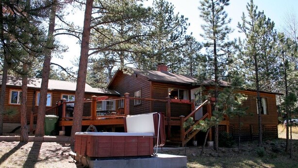 A cabin with a deck, a hot tub, and a staircase leading to a second level. - Mountain Pine Cabin With Personal Hot Tub - Dog-friendly! 3 Bedroom Cabin - #20-NCD0296 (Estes Park)