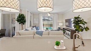 A modern living room with a sofa, a coffee table, and pendant lights. - Plush Pelican, At Storey Lake By Shine Villas #839 4 Bedroom Home (Kissimmee)