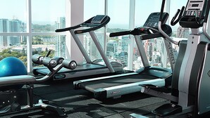 Una palestra con tapis roulant, una cyclette e una palla da ginnastica blu.