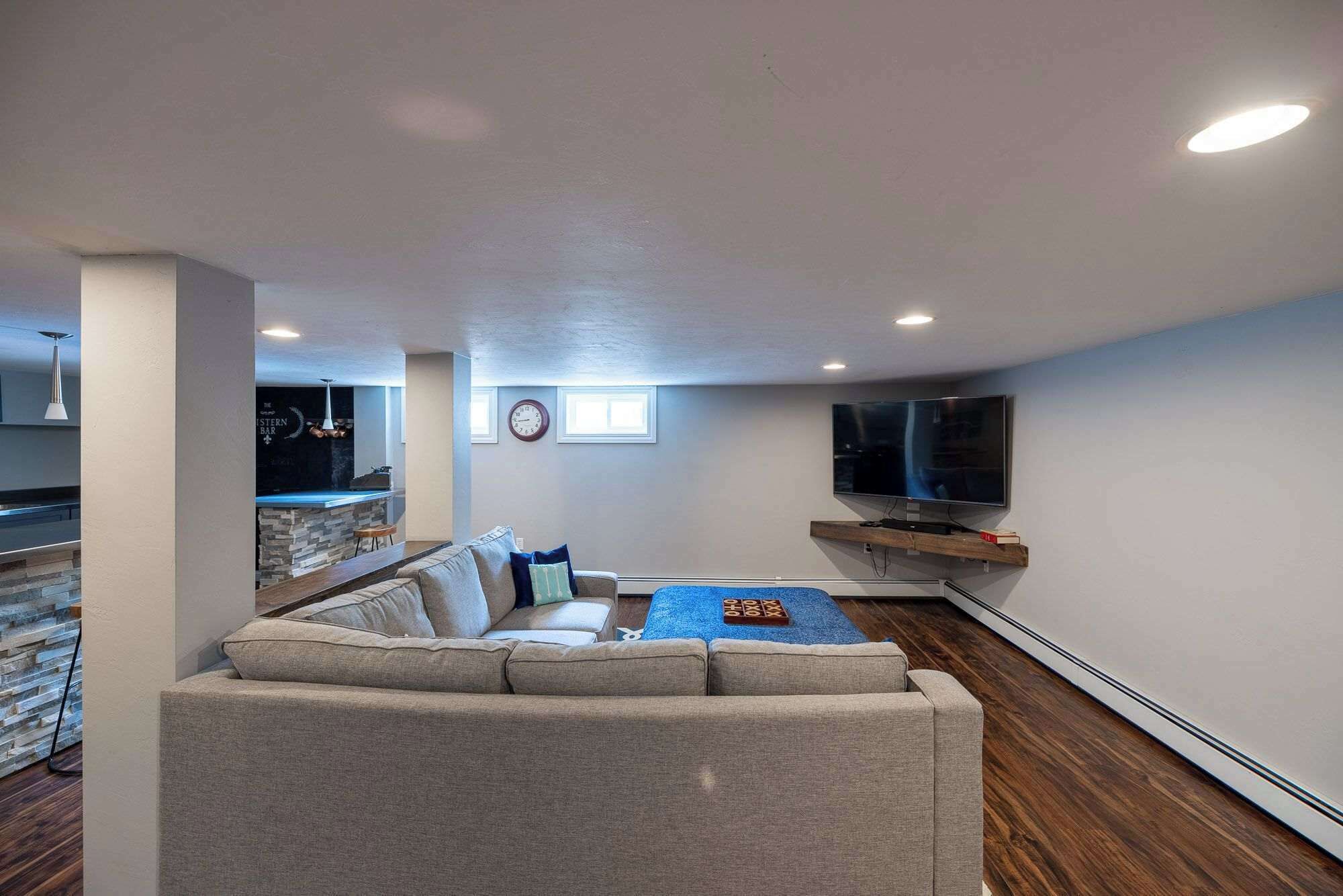 A living room with a sofa, a coffee table, a TV, and a stone wall.