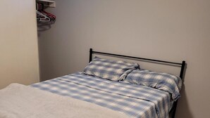 A bedroom with a bed, a wardrobe, and a small window. - Cozy resting place for one (Toronto)