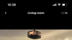 Una sala de estar con chimenea, dos sofás, una mesa de centro y un televisor de pantalla plana sobre la chimenea.