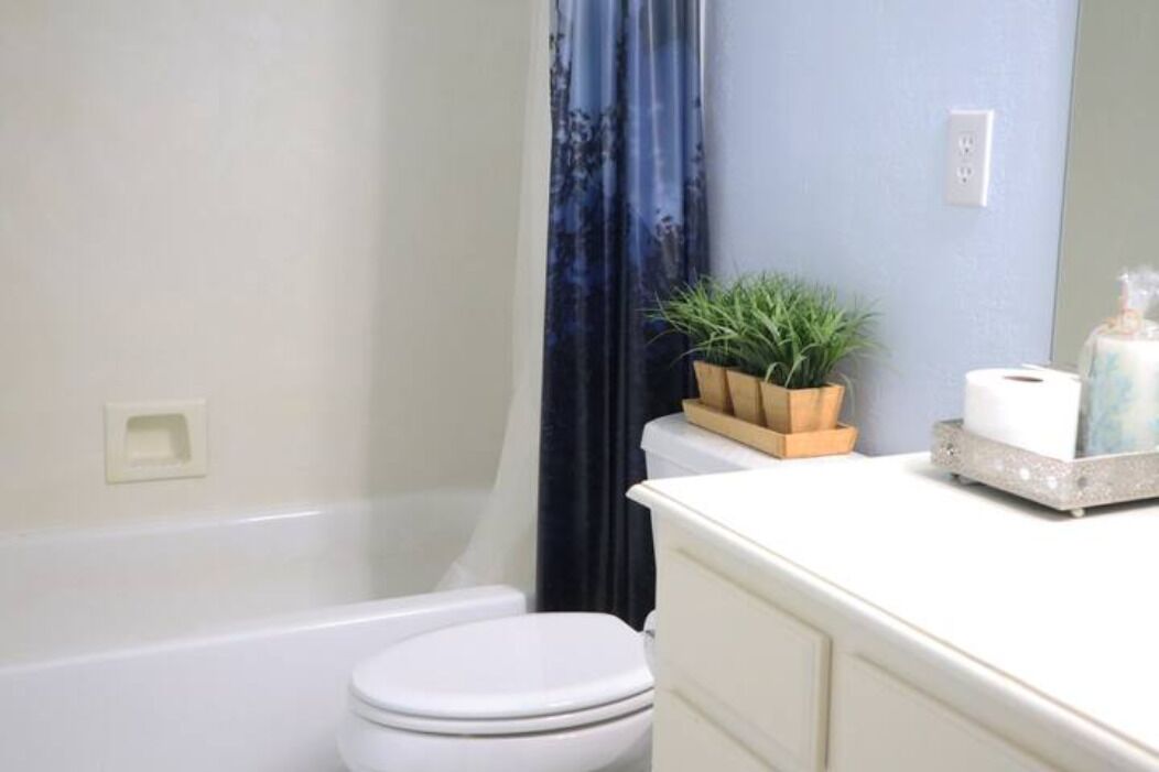 Une salle de bain équipée d’une baignoire, de toilettes et d’un meuble-lavabo avec un miroir.