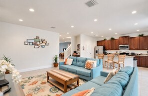 A modern living room with a sofa, coffee table, and a decorative wall.