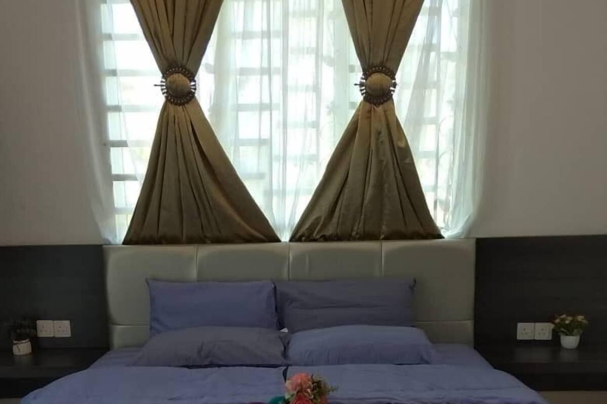 Une chambre à coucher avec un lit, deux tables de chevet et une fenêtre avec des rideaux.