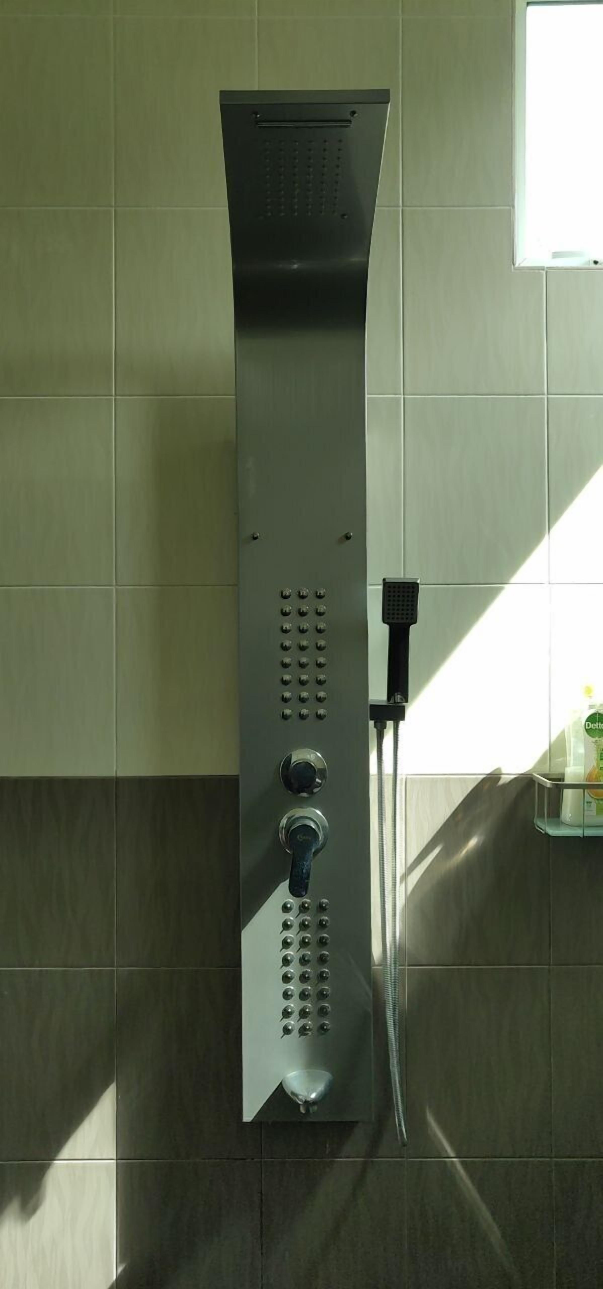 A wall-mounted shower with multiple control knobs and a handheld showerhead.