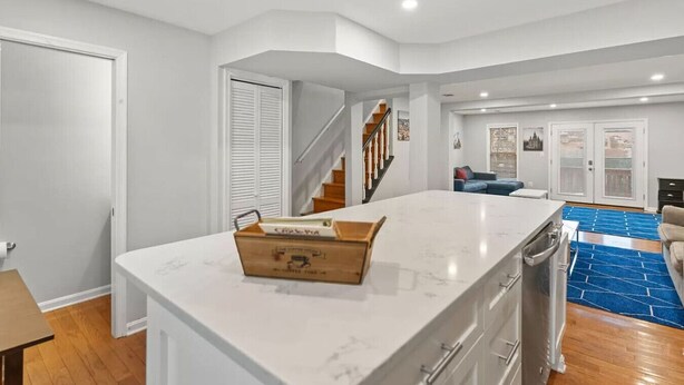 A spacious kitchen with a large island, a dining area, and a staircase leading to another level. - Central Convenient Home | Free Parking | Near U St (Washington)