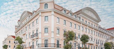 Un hotel grande de varios pisos con un estilo arquitectónico clásico, que destaca por una cúpula central y ventanas simétricas.
