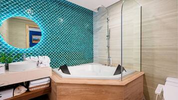 Un baño moderno con una bañera grande, un lavabo y un espejo.