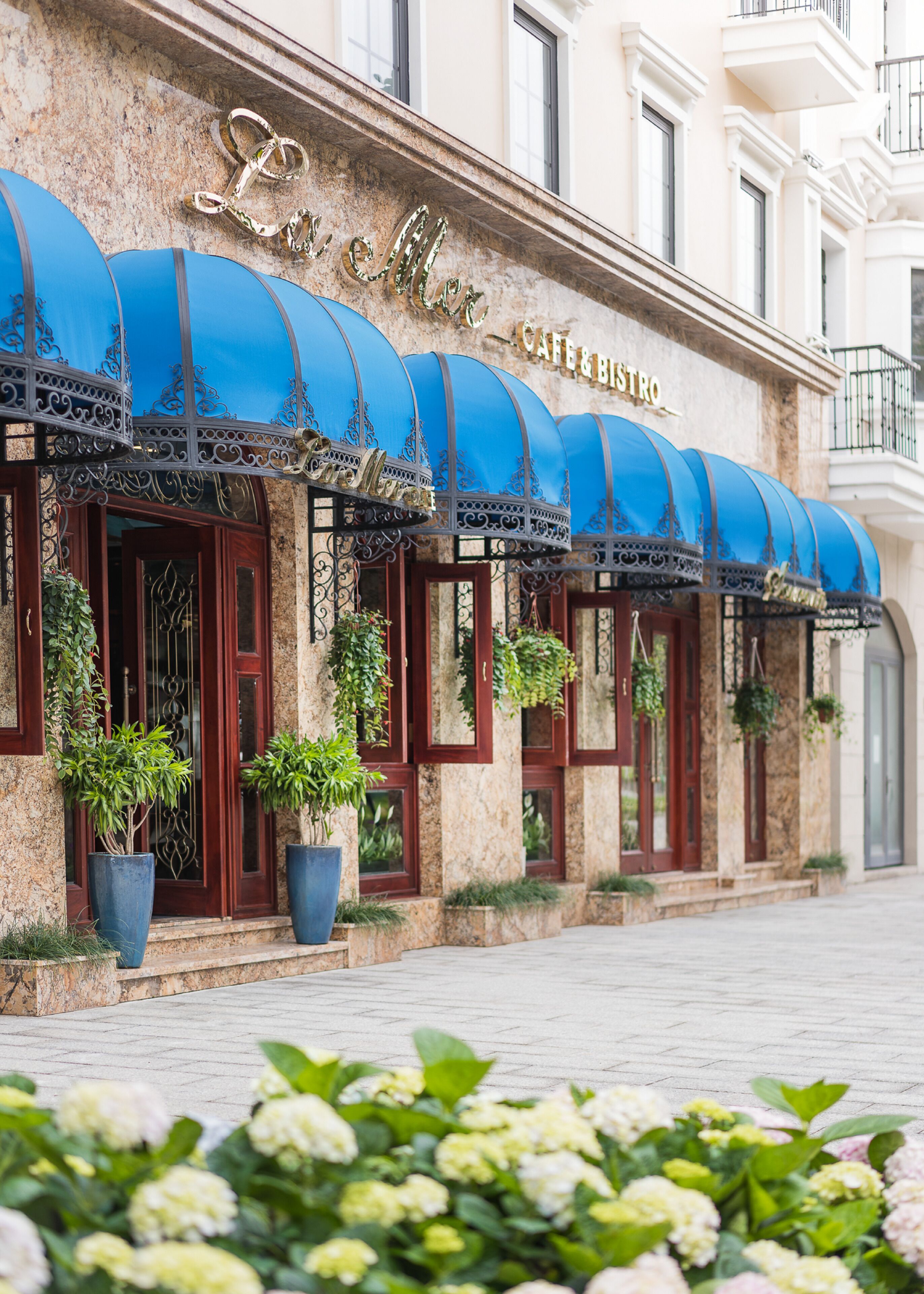 A building with a blue awning and the sign "Cafe & Bistro".