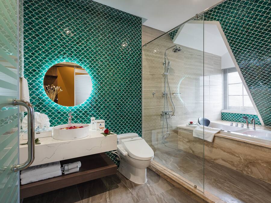 A modern bathroom with a glass-enclosed shower, a white sink, and a toilet.