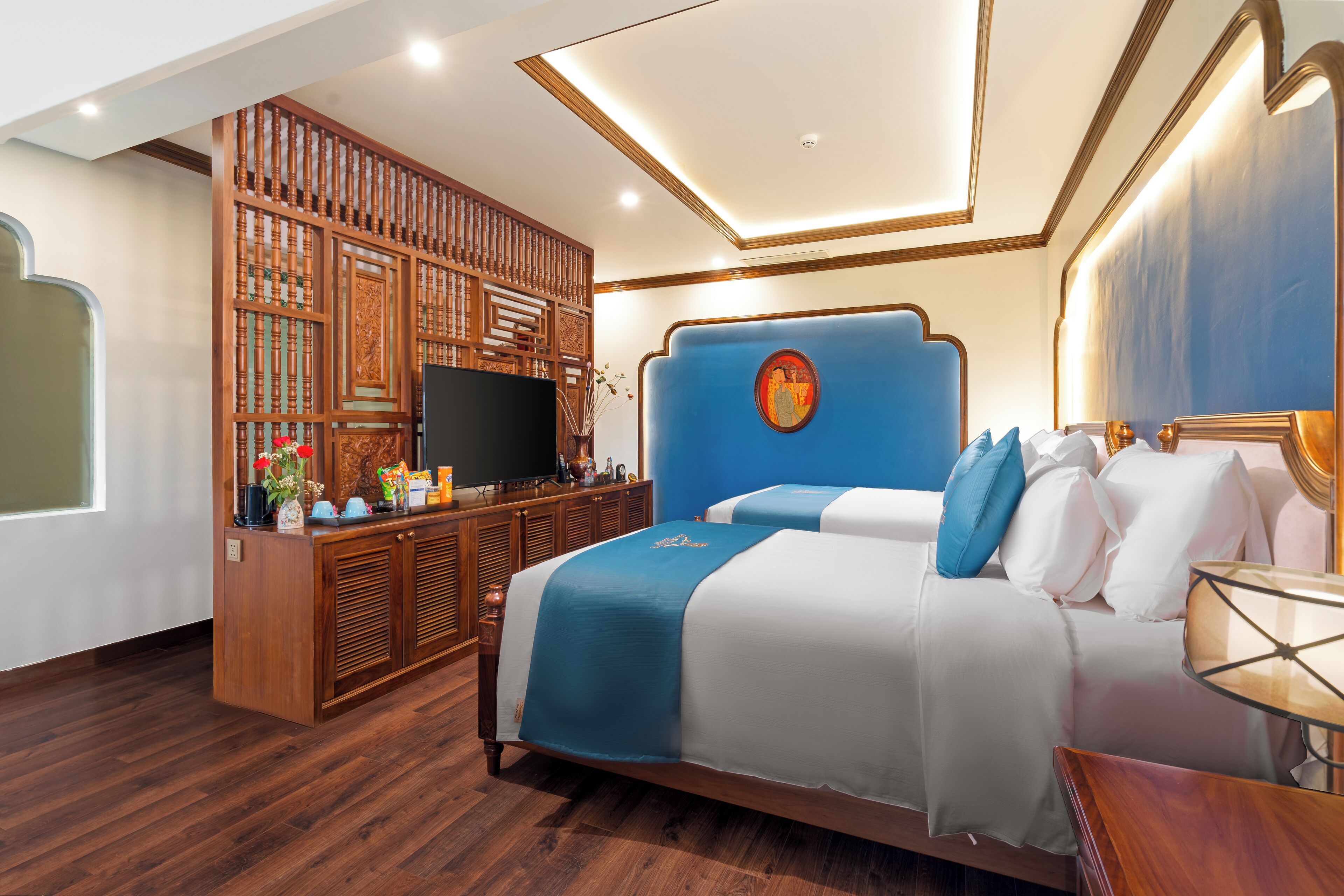 Een hotelkamer met een groot bed, een houten dressoir en een televisie.
