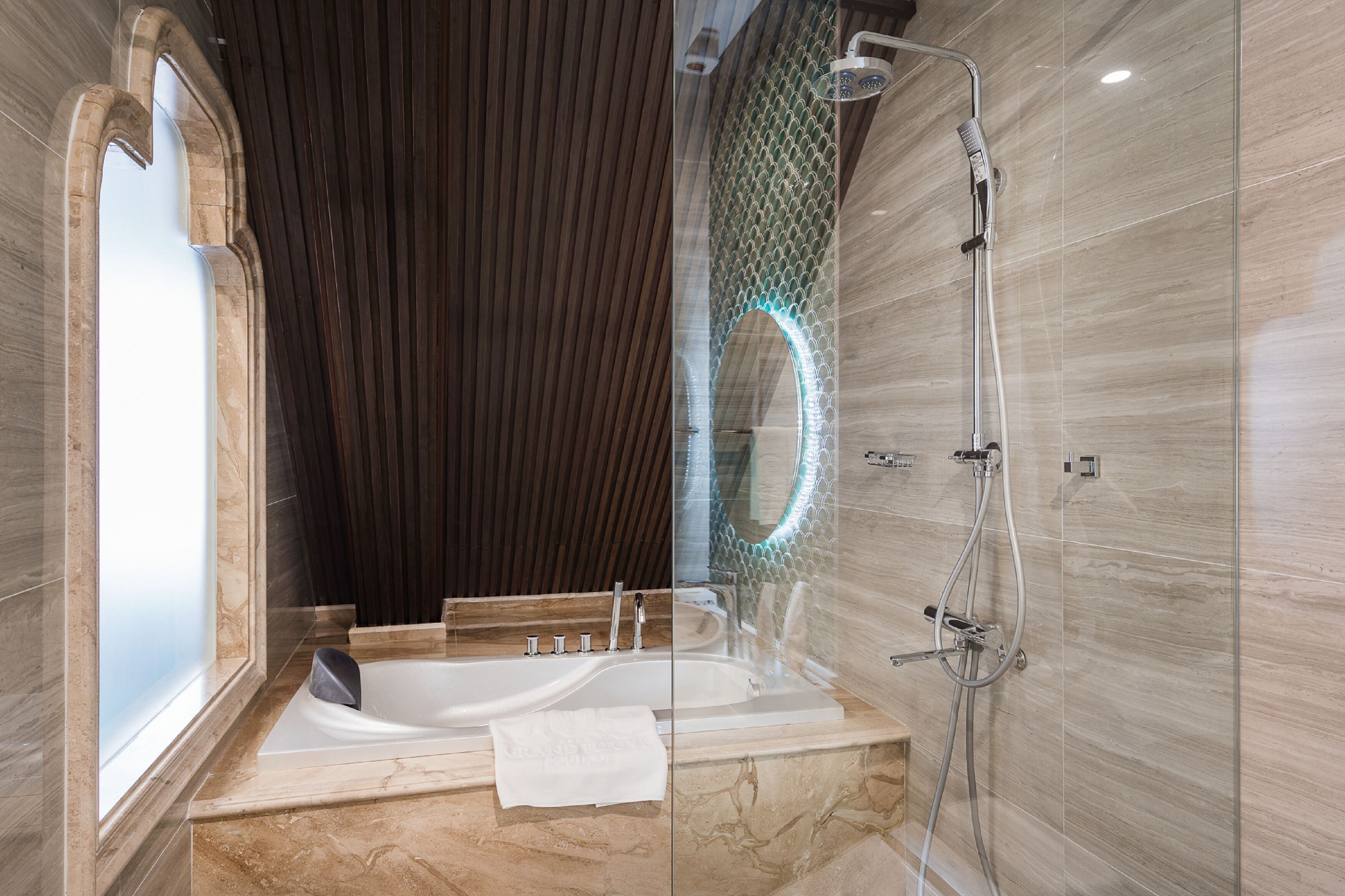 Un baño moderno con una bañera independiente, una ducha con mampara de vidrio y un espejo grande.