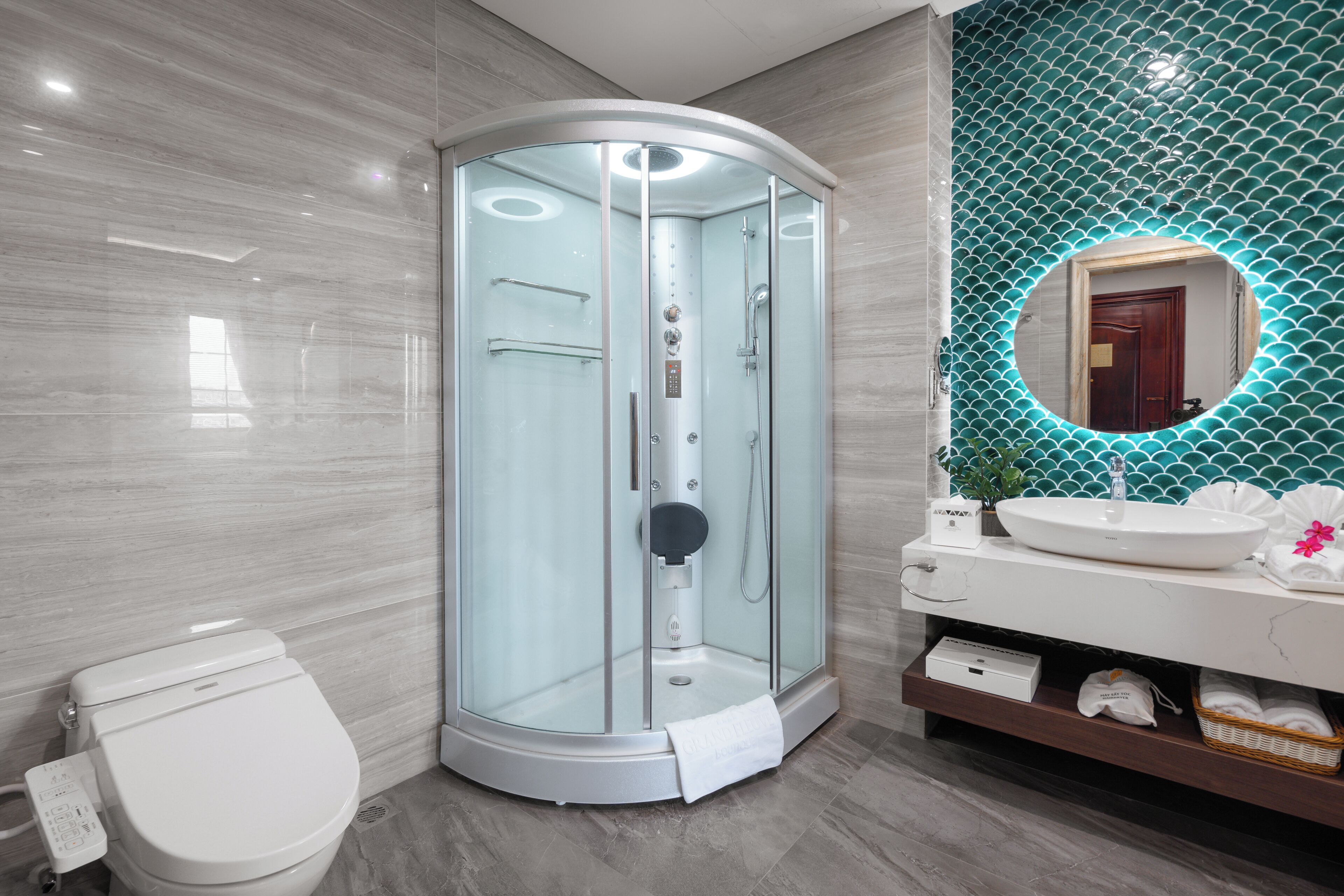 A modern bathroom with a glass-enclosed shower, a white toilet, and a vanity with a mirror.
