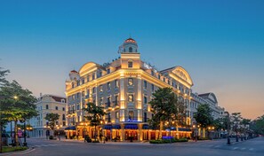 A grand hotel with a classical architectural style, featuring multiple stories, a prominent dome, and illuminated signage. - Grand Fleuve Boutique  (Bai Chay)
