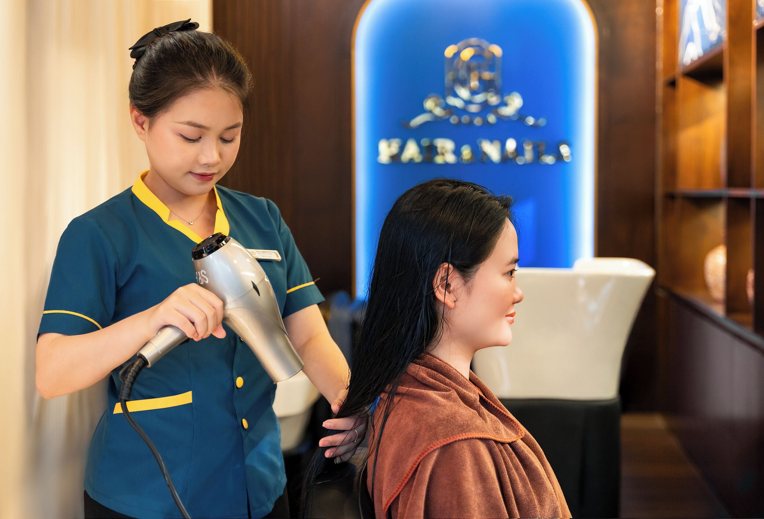 Un service de coiffure proposé dans un salon, avec un logo bien visible sur le mur.