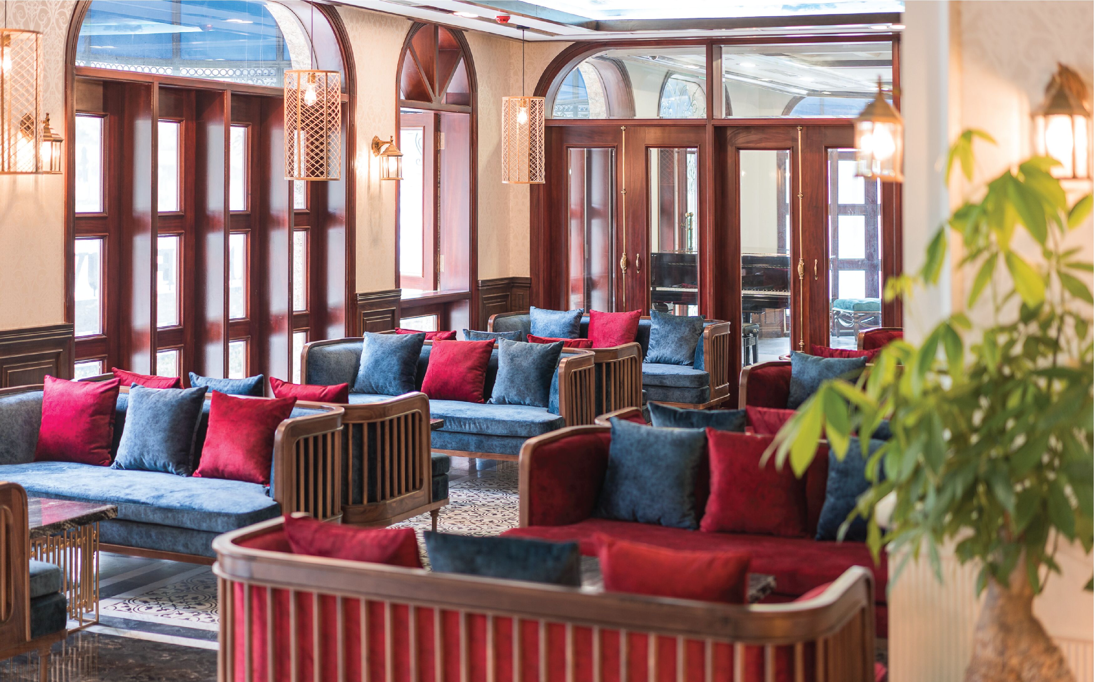 A lobby with rows of seating, large windows, and decorative lighting.