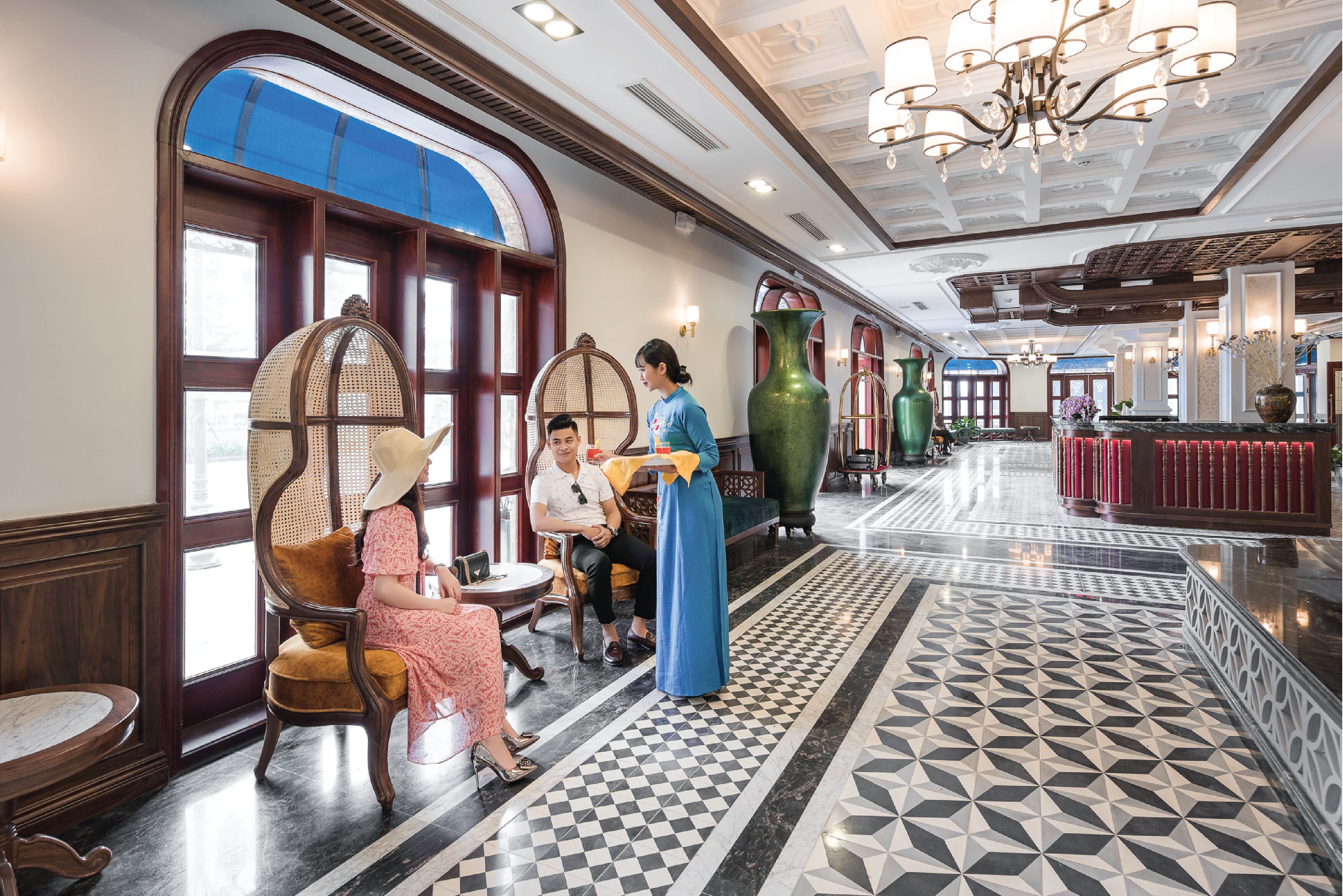 A lobby with a checkered floor, large windows, and a reception desk.