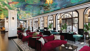 A spacious lounge with red and teal sofas, large windows, and a ceiling mural. - Grand Fleuve Boutique  (Bai Chay)