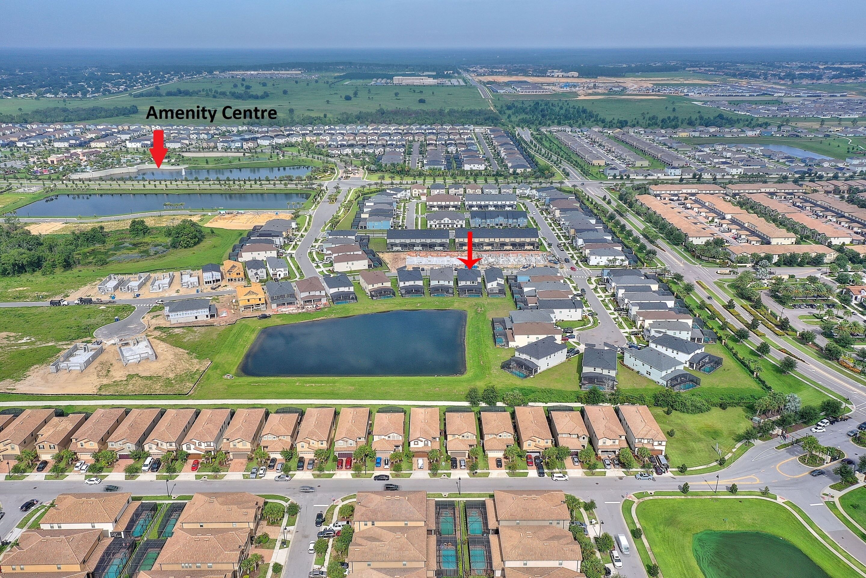 Vista aérea de una zona residencial con un amplio centro de servicios, varias piscinas y un espacio verde cuidado.