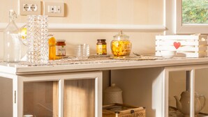 A kitchen with a white cabinet containing storage boxes and glass jars. - Casa Pralunghi b&b  (Calvene)