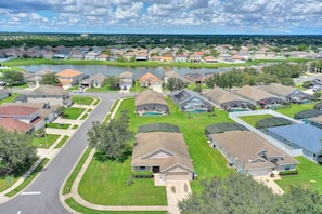 Zona residencial con casas, una carretera y un lago.