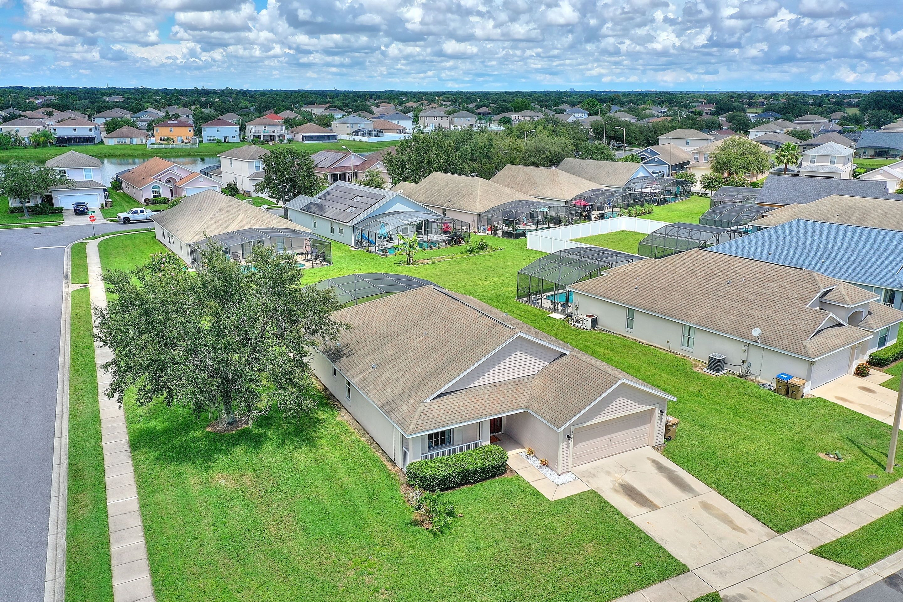 A residential area with houses, a road, and a grassy area.