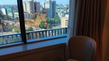 A room with a large window, a round table, and a chair.