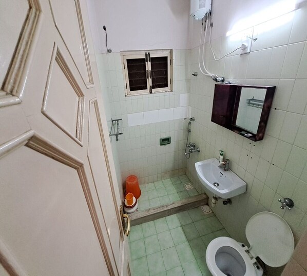 A small bathroom with a toilet, sink, and a window above the sink.