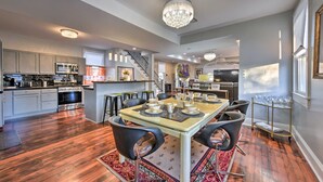 A spacious kitchen with modern appliances, a dining area with a chandelier, and a staircase leading to another level. - 3 Mi to French Quarter: Family Home in New Orleans (New Orleans)