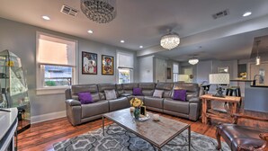 A modern living room with a sectional sofa, a coffee table, and a chandelier. - 3 Mi to French Quarter: Family Home in New Orleans (New Orleans)