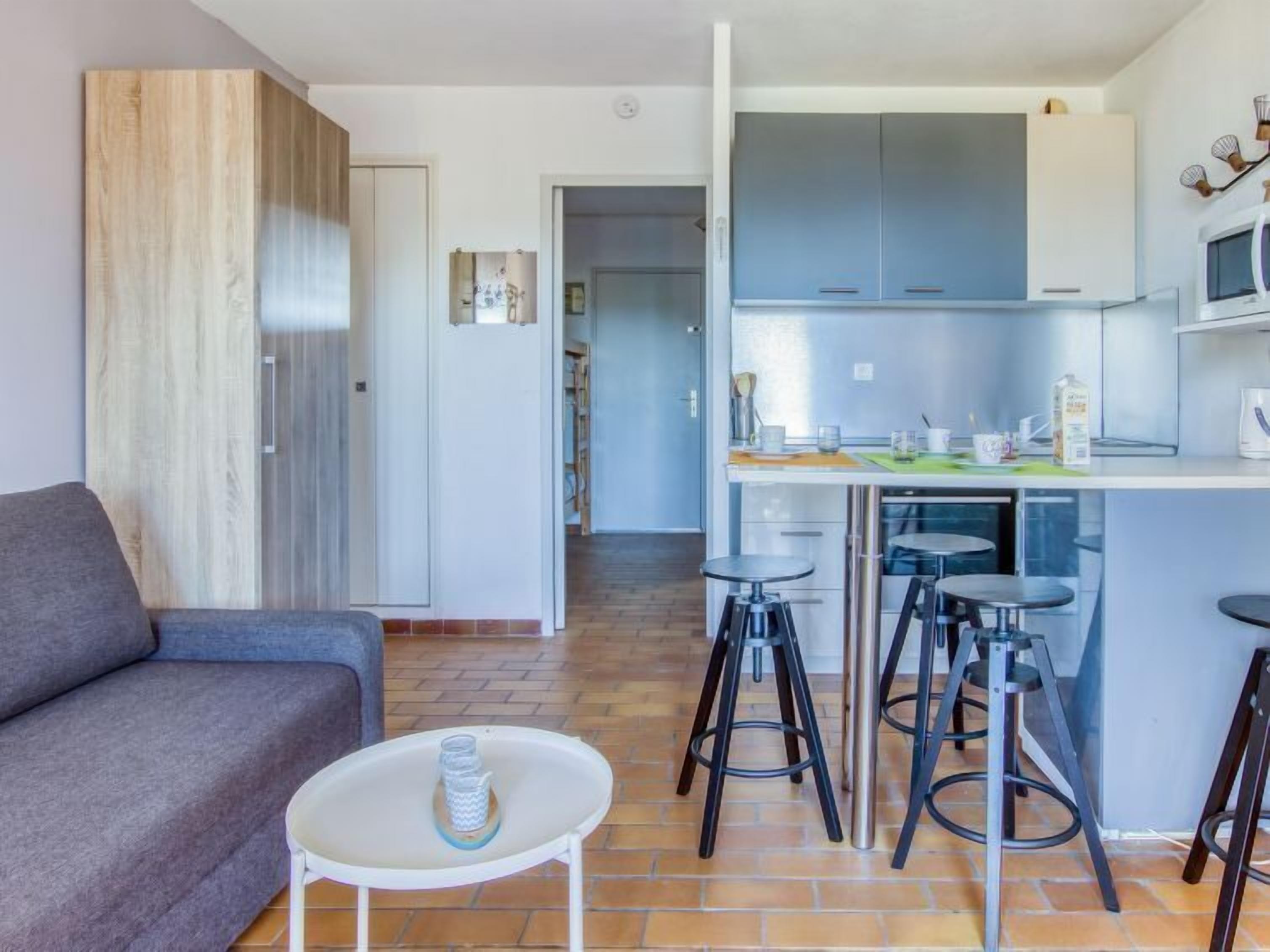 Een moderne keuken met barstoelen, een eettafel en een bank in een zithoek.
