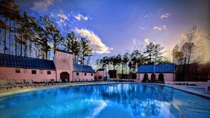 A swimming pool with a reflection of the sky and trees, surrounded by buildings with a clock tower. - Serenbe, Palmetto, Ga, Escape, Serenity, Unforgettable, Scenic, Relaxation, New (Palmetto)