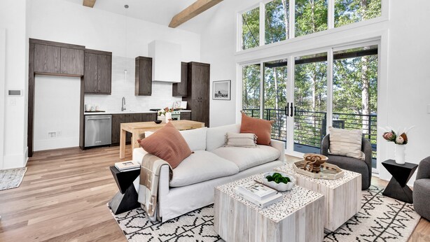 A spacious living area with a large window, a modern kitchen, and a cozy seating arrangement. - Serenbe, Palmetto, Ga, Escape, Serenity, Unforgettable, Scenic, Relaxation, New (Palmetto)