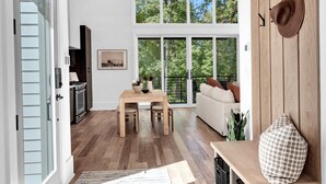 A spacious living area with a wooden ceiling, a dining table, and a sofa. - Serenbe, Palmetto, Ga, Escape, Serenity, Unforgettable, Scenic, Relaxation, New (Palmetto)