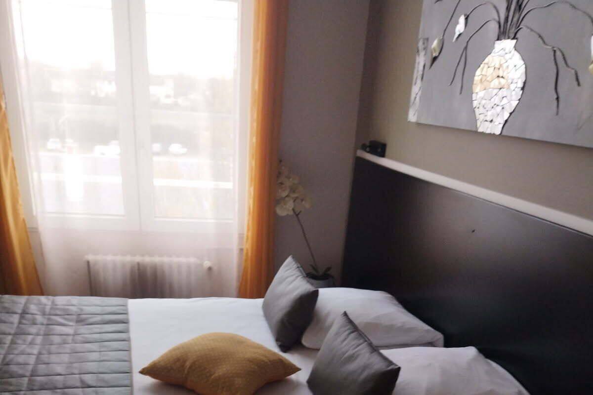 Une chambre d’hôtel avec un lit, une chaise et un tableau au mur.
