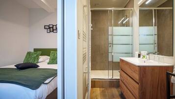 Deluxe appartement | Badkamer | Een douche, een haardroger, handdoeken, shampoo