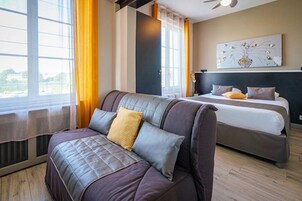 Habitación cuádruple Deluxe, vistas al complejo turístico | Zona de estar | Una televisión