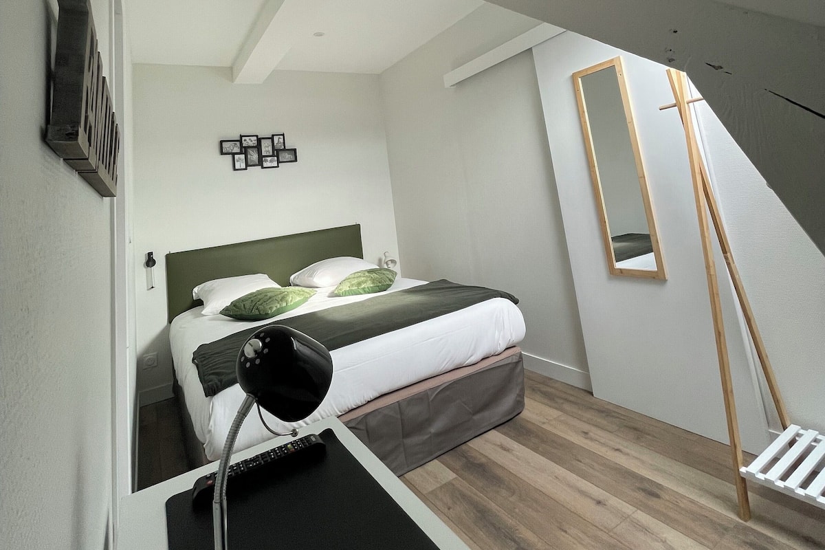Une chambre à coucher moderne avec un lit, un bureau et un miroir.