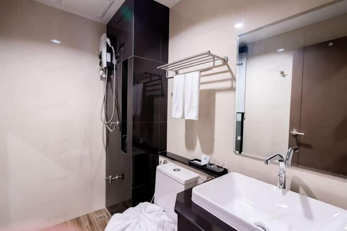Un baño moderno con ducha, inodoro, lavabo y toallero.