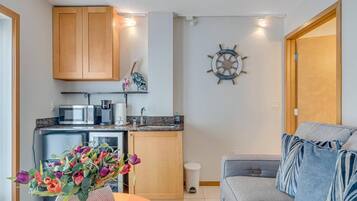 A compact living space with a kitchenette, a dining area, and a seating area with a sofa.