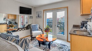 Un apartamento moderno con balcón, cocina y sala de estar.