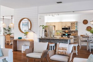 A modern kitchen with white cabinetry, stainless steel appliances, and a central island.