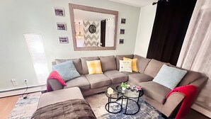 A living room with a sectional sofa, a coffee table, and a rug.